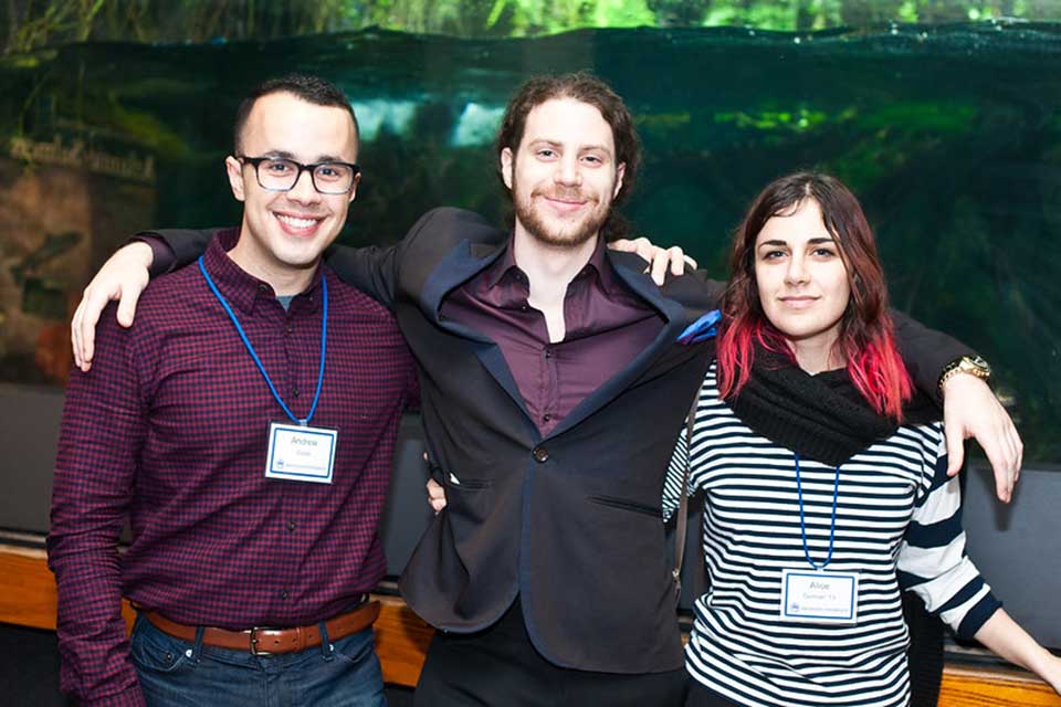Three alumni pose for the camera at an event at the New England Aquarium