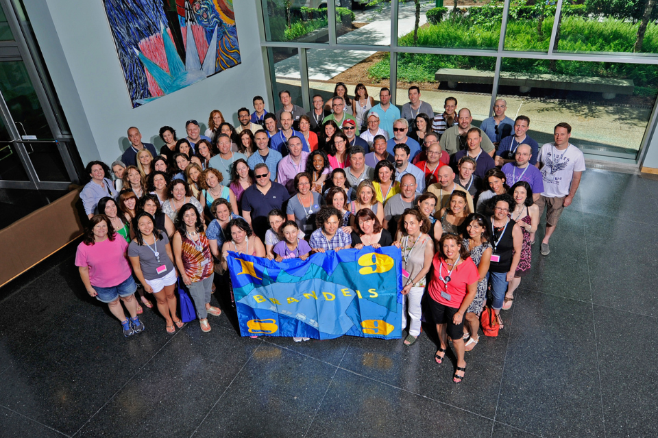 group of alumni from class of 1989 gathered holding class flag