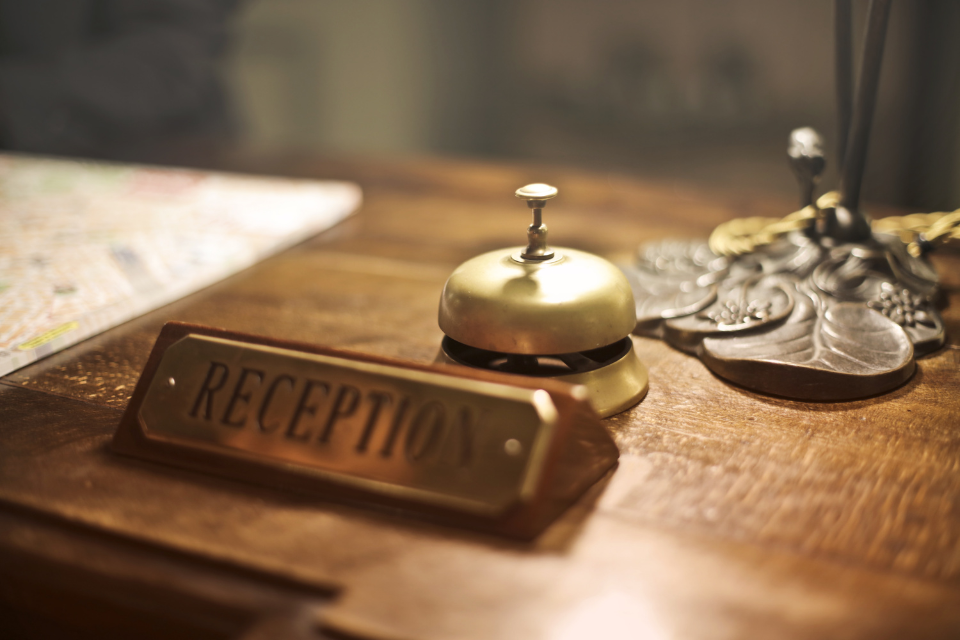 Hotel reception desk with a bell and reception sign