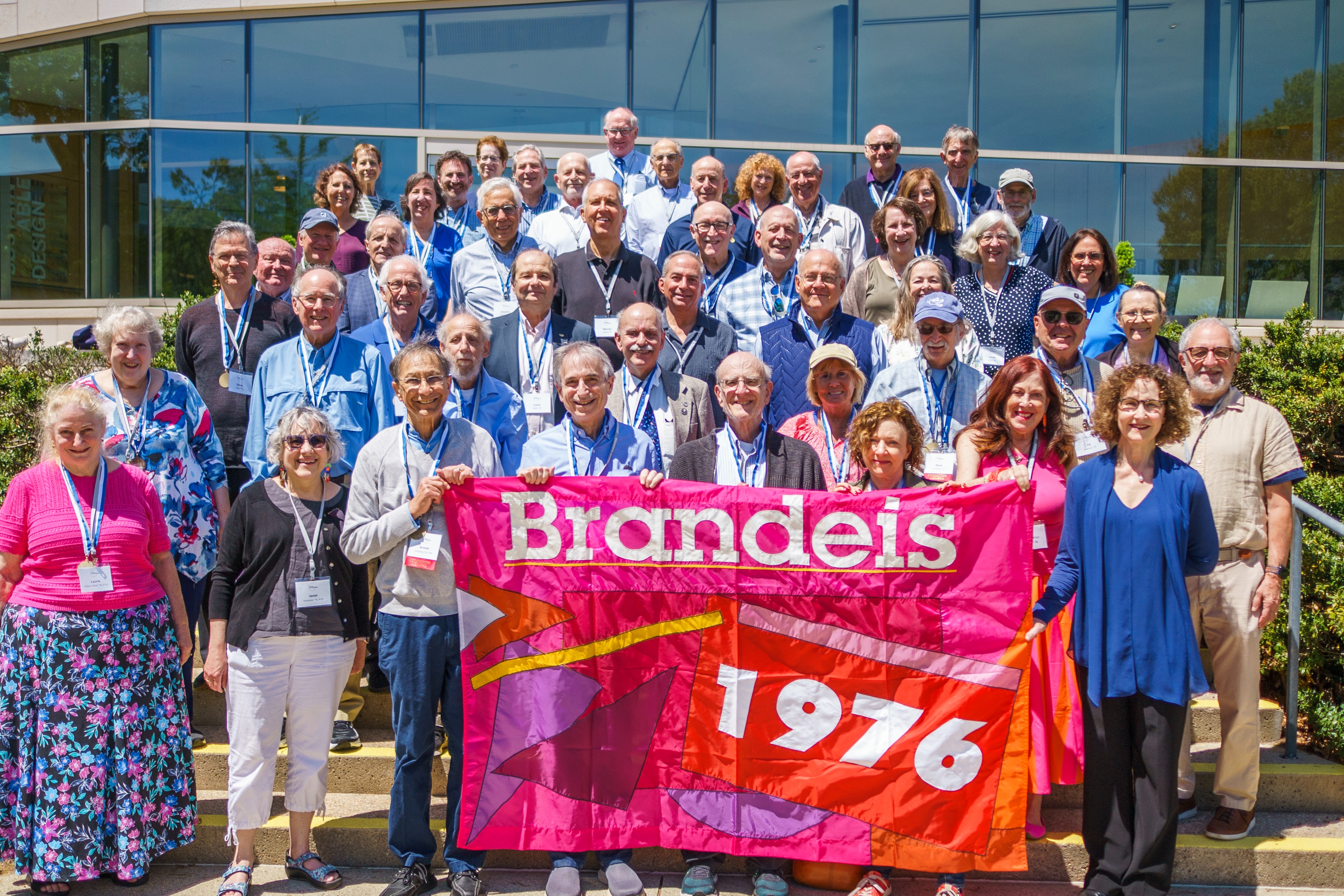 Members of the class of 1976 posing in front of the Carl and Ruth Shapiro Admissions Center