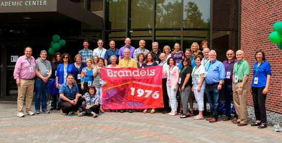 alumn in commencement regalia smiling at the camera during his 50th reunion