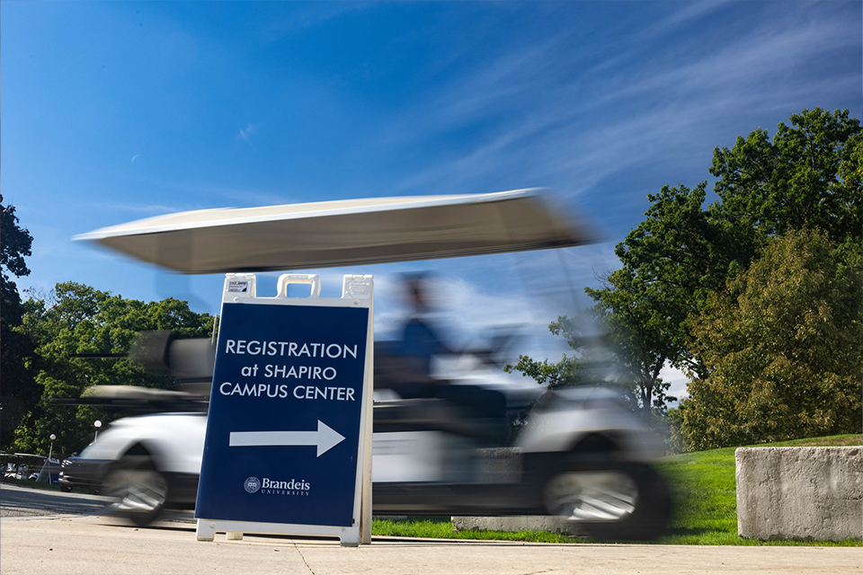 golf cart zooming behind a registration sign