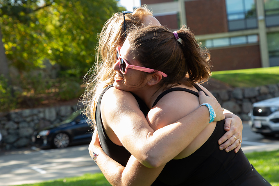 Two young female alumni hugging