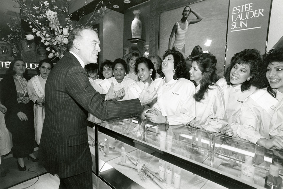 Leonard Lauder laughing with employees at Bloomingdales