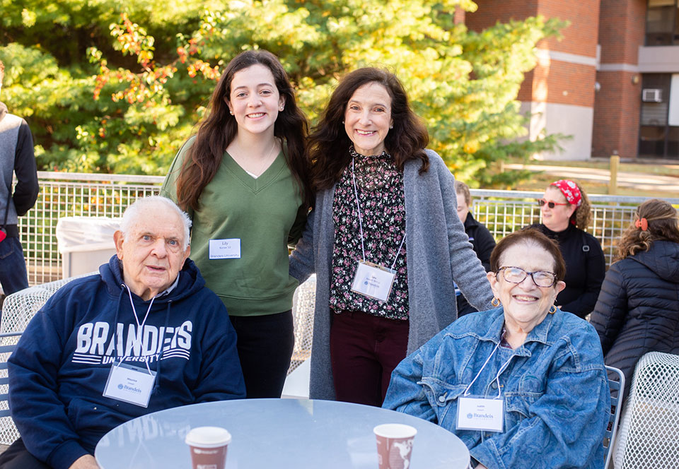 Four family members of various ages smiling and posing for a photo.