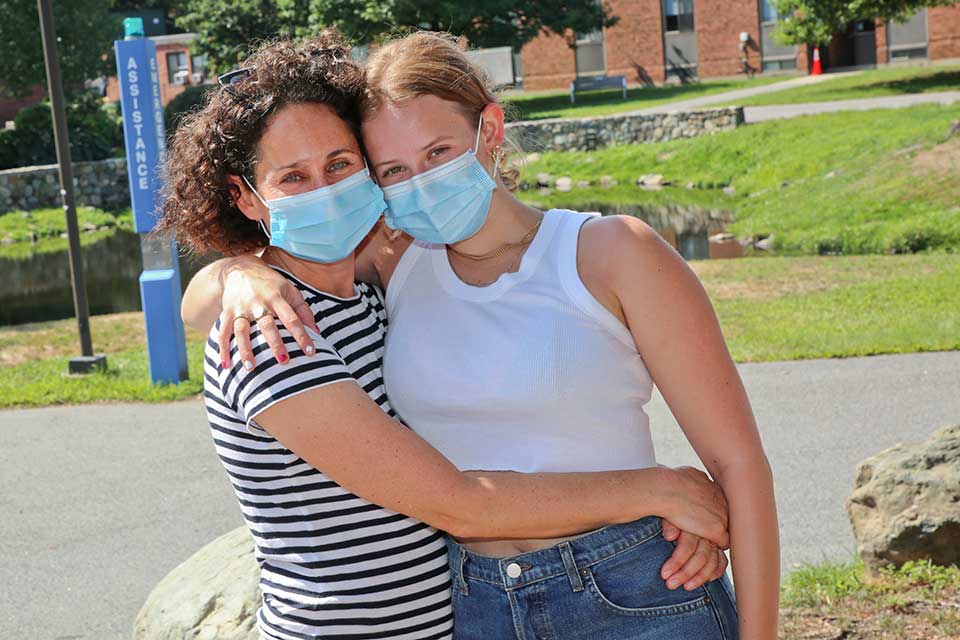 mother and daughter embracing and wearing masks
