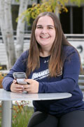 student holding cell phone outside