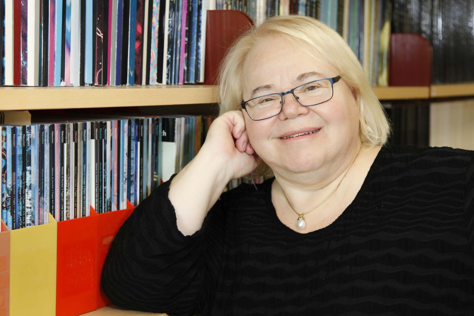 Photo of Professor Eve Marder smiling in her book-lined office.