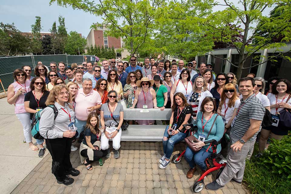 Members from the Class of 1989 gathered around a bench in memory of classmate Michael “BEMCo” Guttenberg ’89 