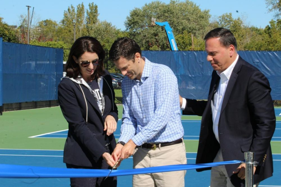 Melissa (left) and Jonathan Cordish (center) cut the ribbon at the dedication of the Cordish Tennis Center as President Ronald Liebowitz looks on. 