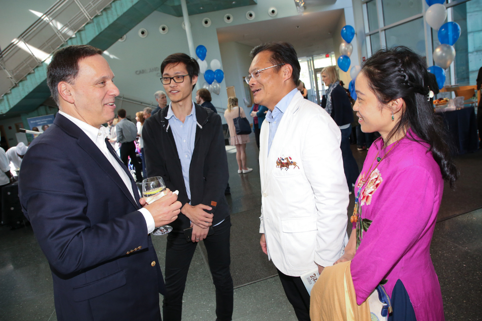 President Ron Liebowitz talks with a Chinese Brandeis student and their family at an on-campus event