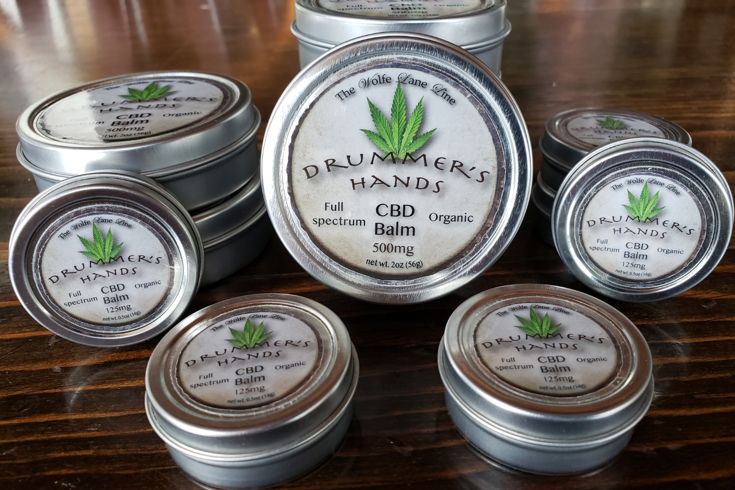 Multiple tin cans of Drummer’s Hands CBD Balm