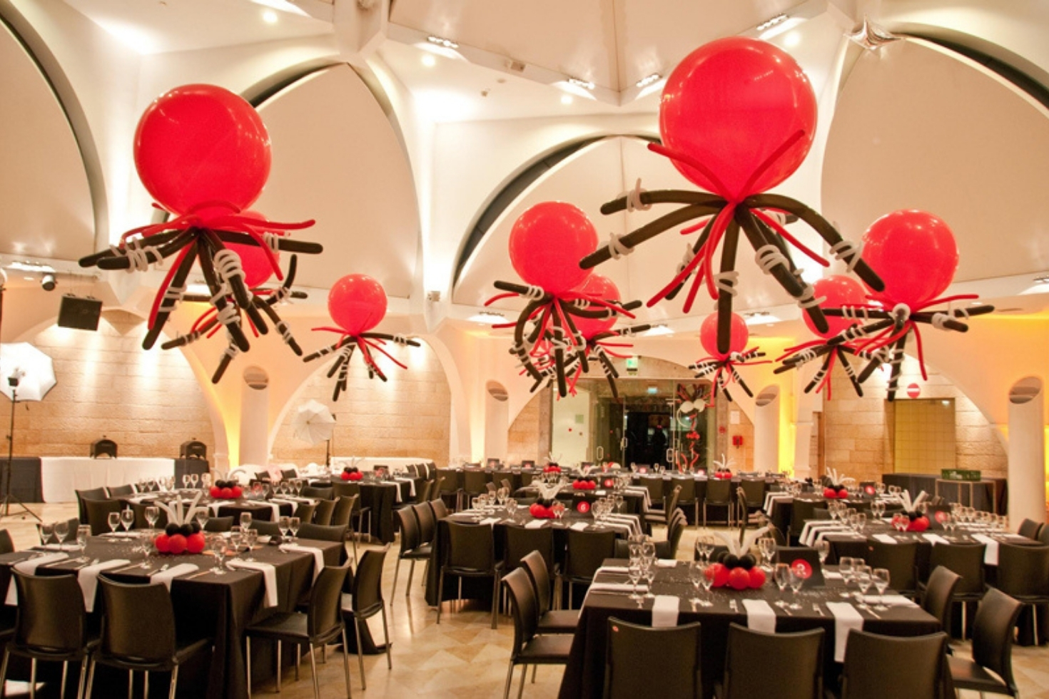 Multiple tables in a ballroom with large balloon centerpieces