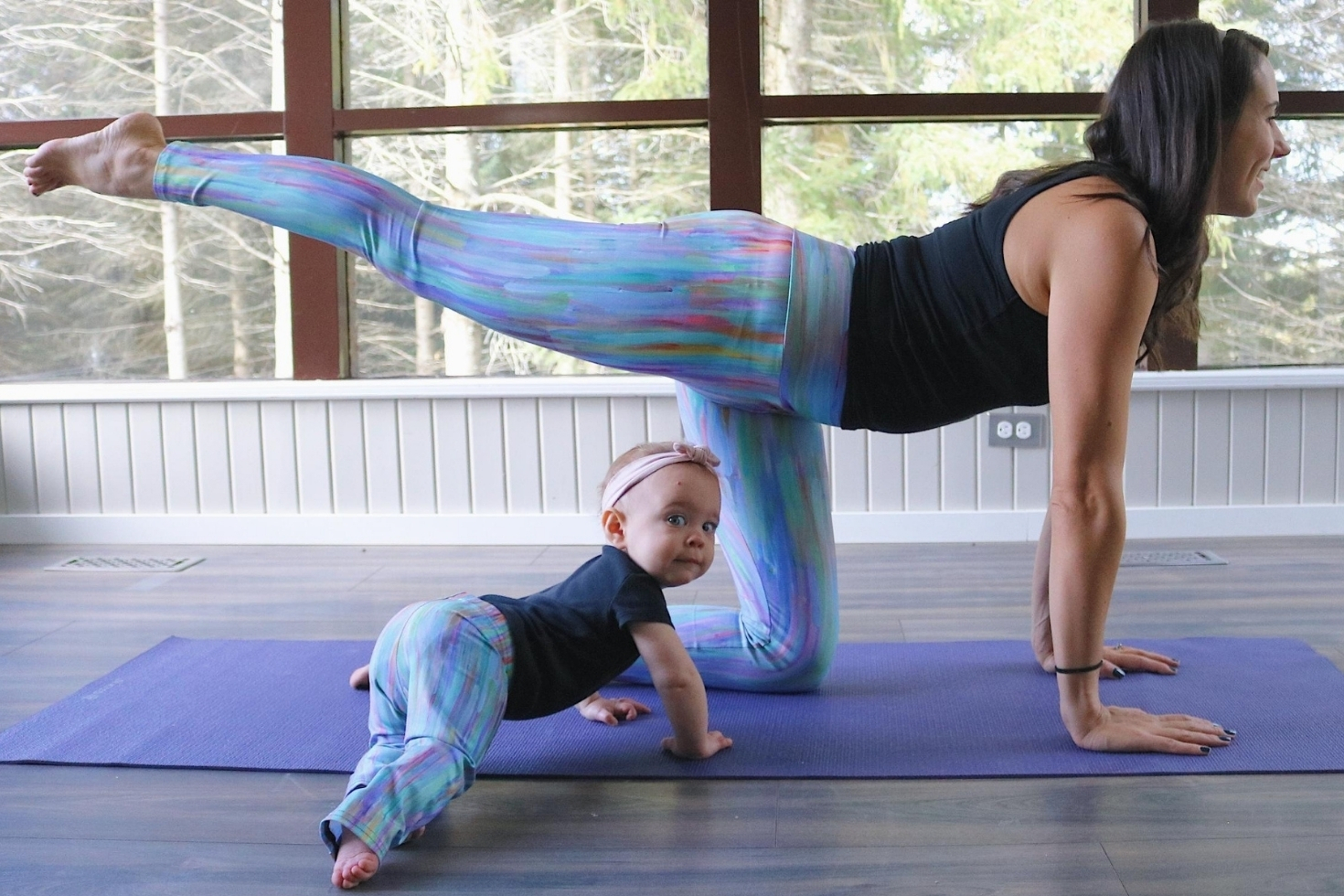 Mom and infant daughter wearing matching leggings in a yoga pose
