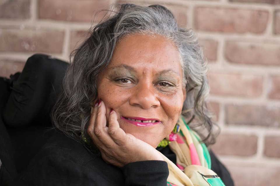 Deidre Davis Butler ’77 smiling with hand on chin