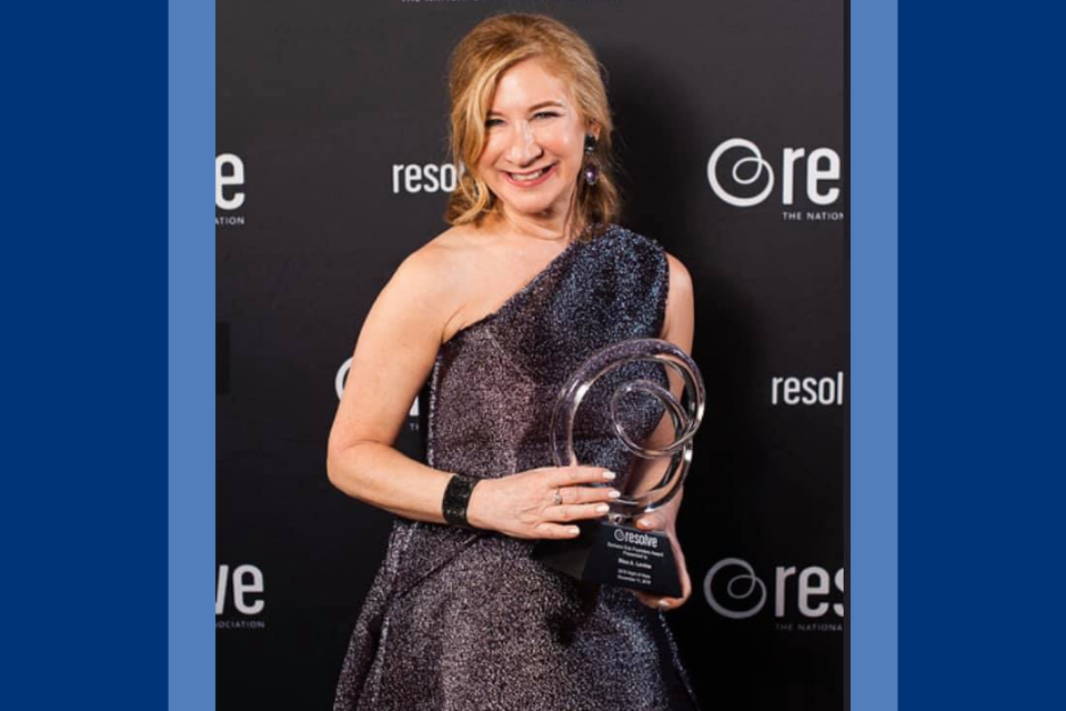 Risa Levine holds award in front of Resolve backdrop