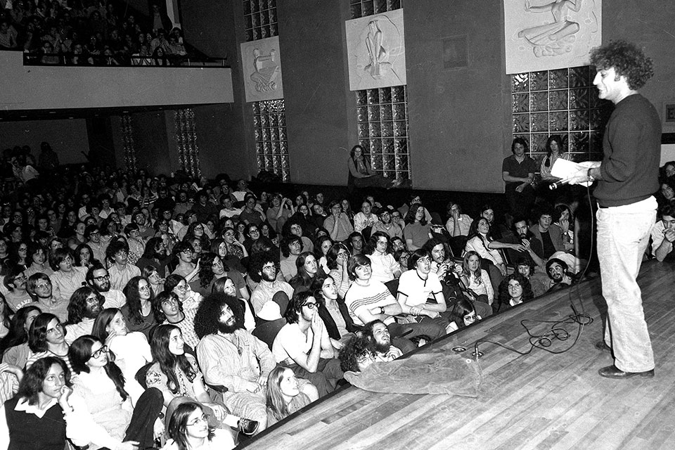 Abbie Hoffman speaking onstage to Brandeis students in 1972
