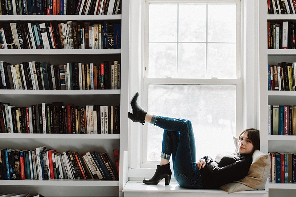 Elizabeth Bruenig lying down on a window seat