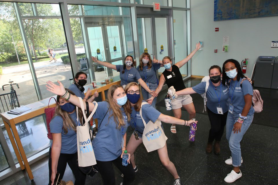 a group of students wearing masks pose cheerfully 