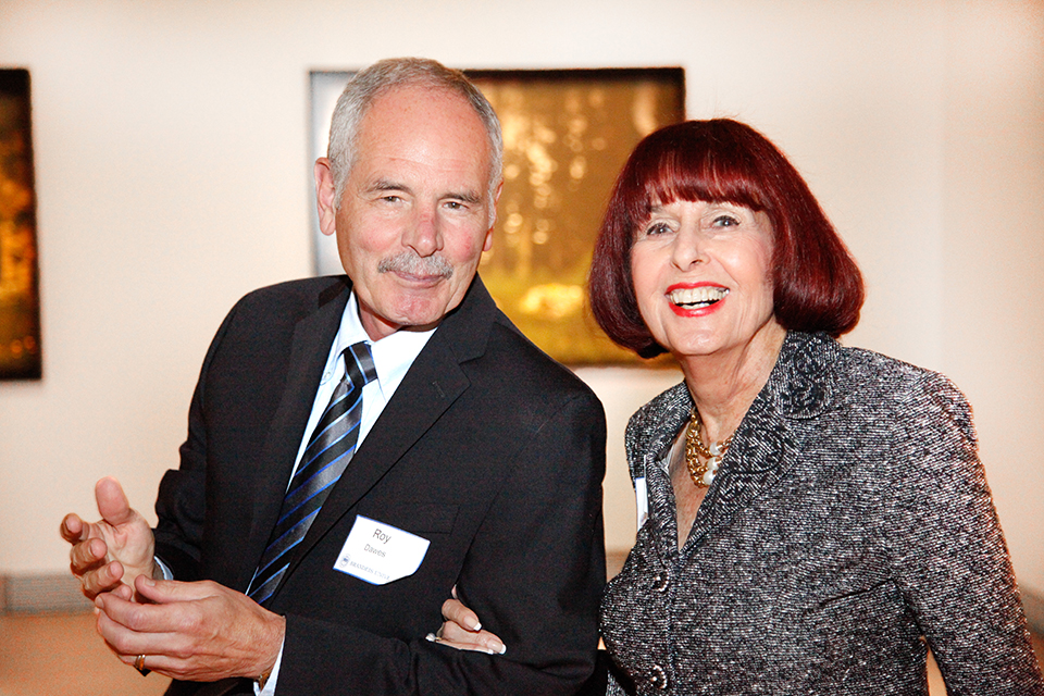 Lois Foster (center) smiling with Roy Dawes at The Rose Art Museum