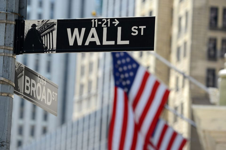 Photo of Wall St. sign post with American flag