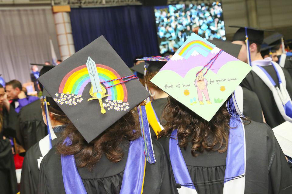 One mortarboard decorated with a rainbow, and another that says think of how far you've come.