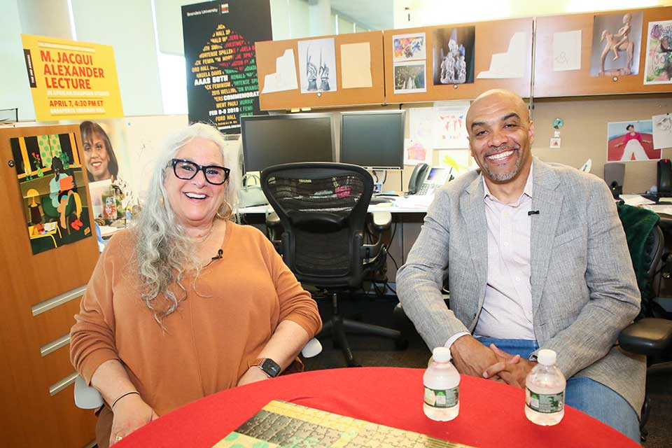 Marta Kauffman and Chad Williams sitting at a table and smiling. 