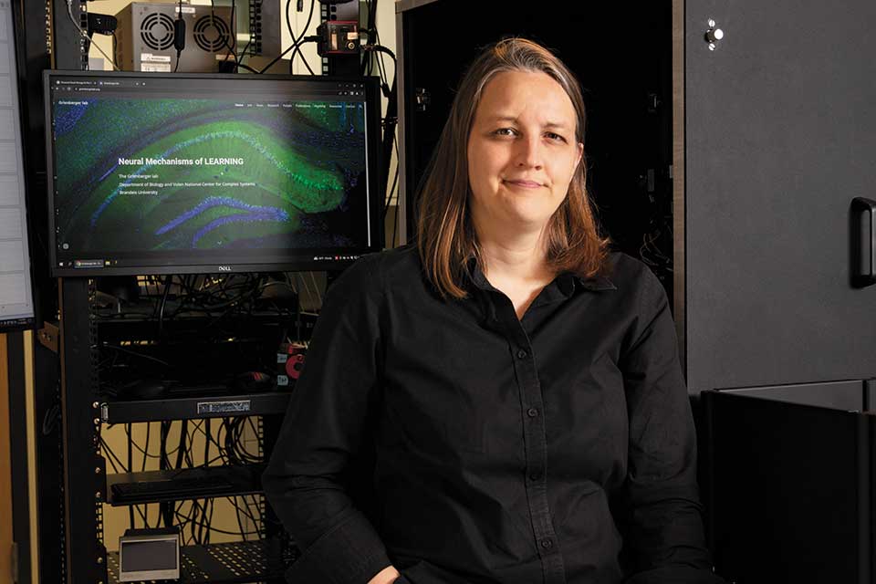 Woman dressed in black stands in front of a cart holding a computer.