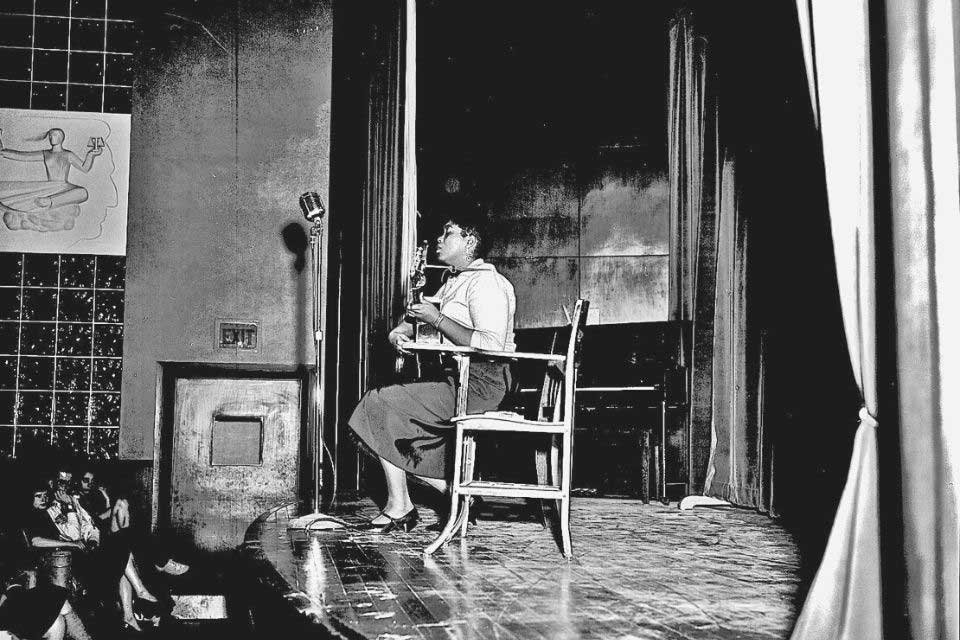 Odetta playing  the piano in front of an audience 