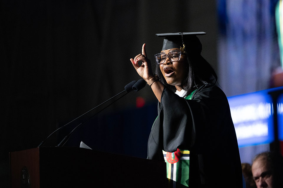 Giselle Gabriel delivers remarks at the podium during the graduate Commencement ceremony.