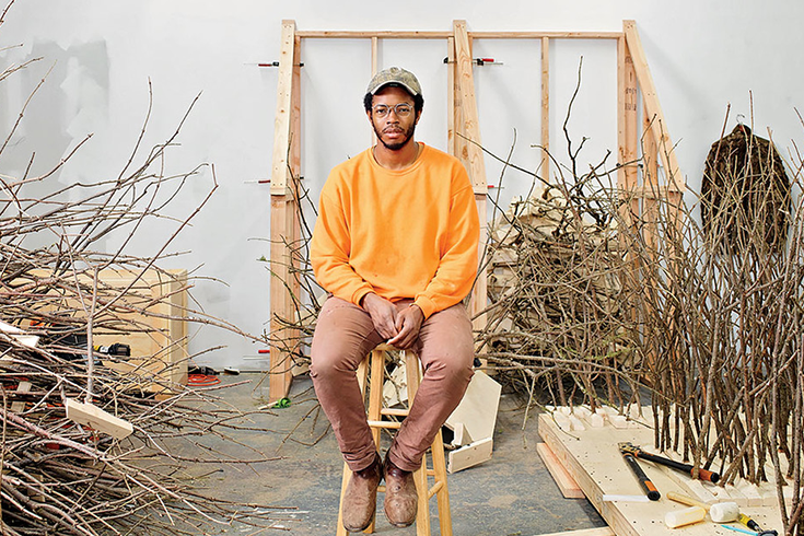 Hugh Hayden sitting amongst his sculptures