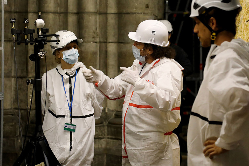 A person does acoustics work inside Notre Dame cathedral