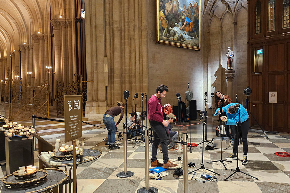 Several people look into the acoustics of Notre Dame Cathedral in Paris