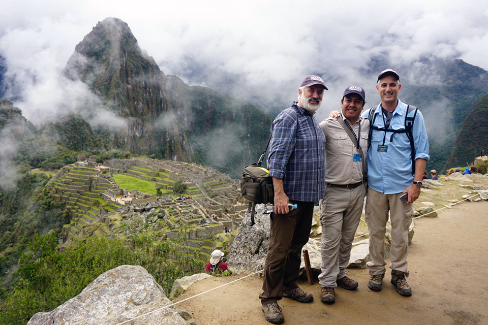 Alumni standing atop a peak at Machu Pichu