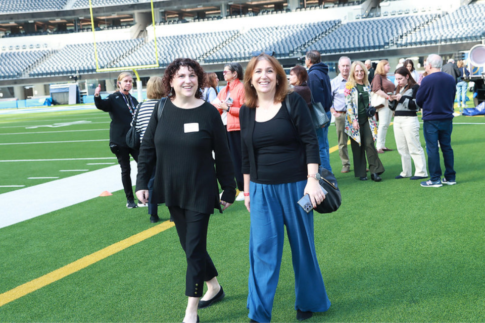 Alumni on the field of Sofi Stadium in LA for a Faculty in the Field event