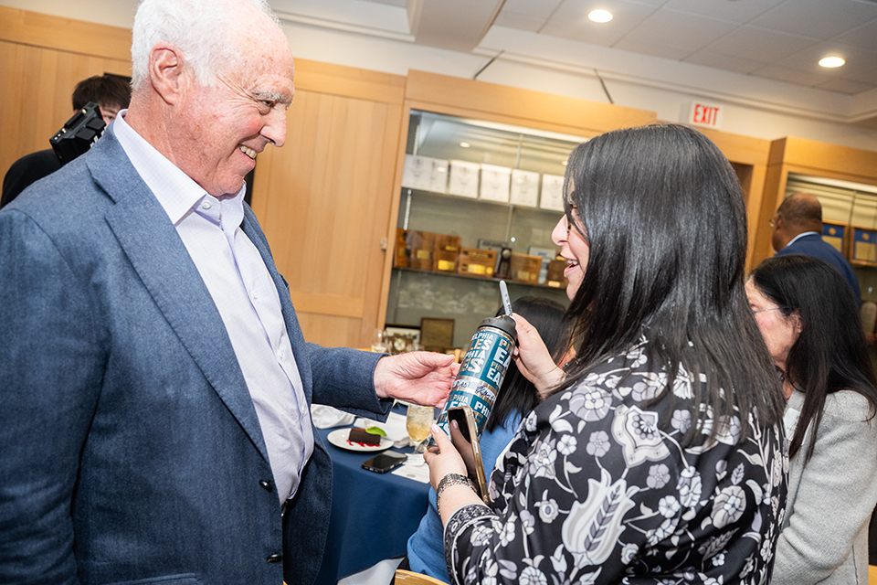 Jeffrey Lurie signing an Eagles water bottle for an alumni fan