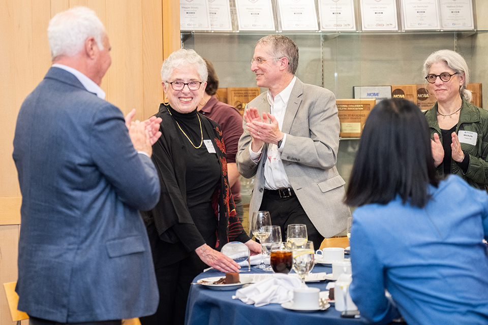 Sheila Taube receiving applause for winning the alumni achievement award