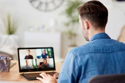 Man siting at a laptop on a video call.