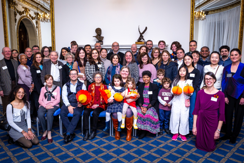 Several people smile in a group photo taken at a gathering of Brandeis alumni in London.