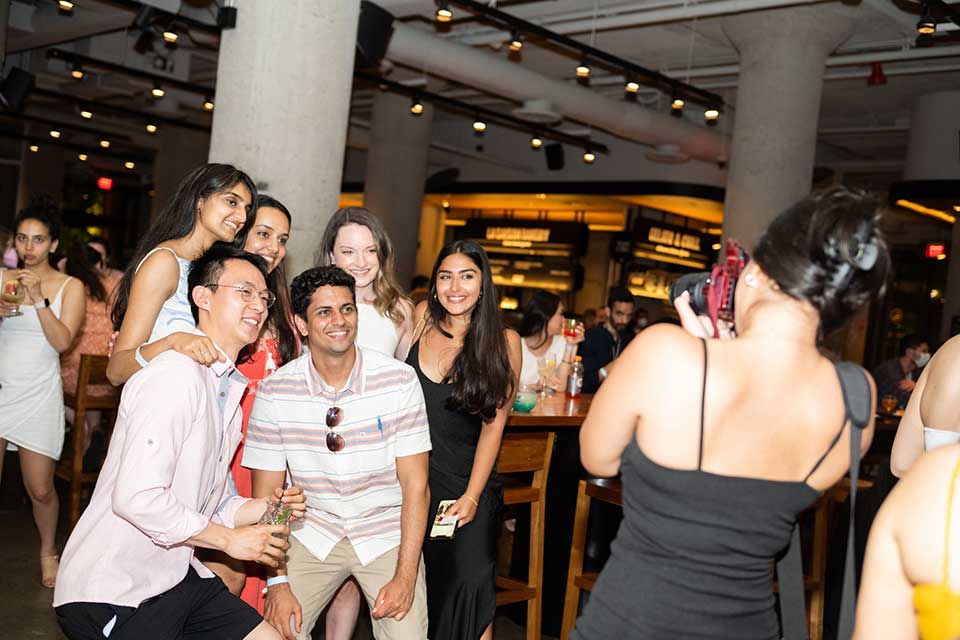 A group of alumni pose for a picture at the Time Out Market