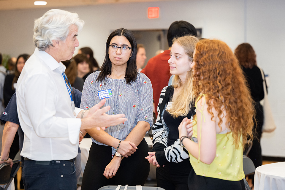 An alum speaking with a group of female students at DeisDinner in the Fall of 2024
