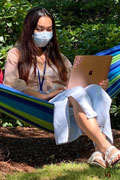 person wearing mask holding laptop