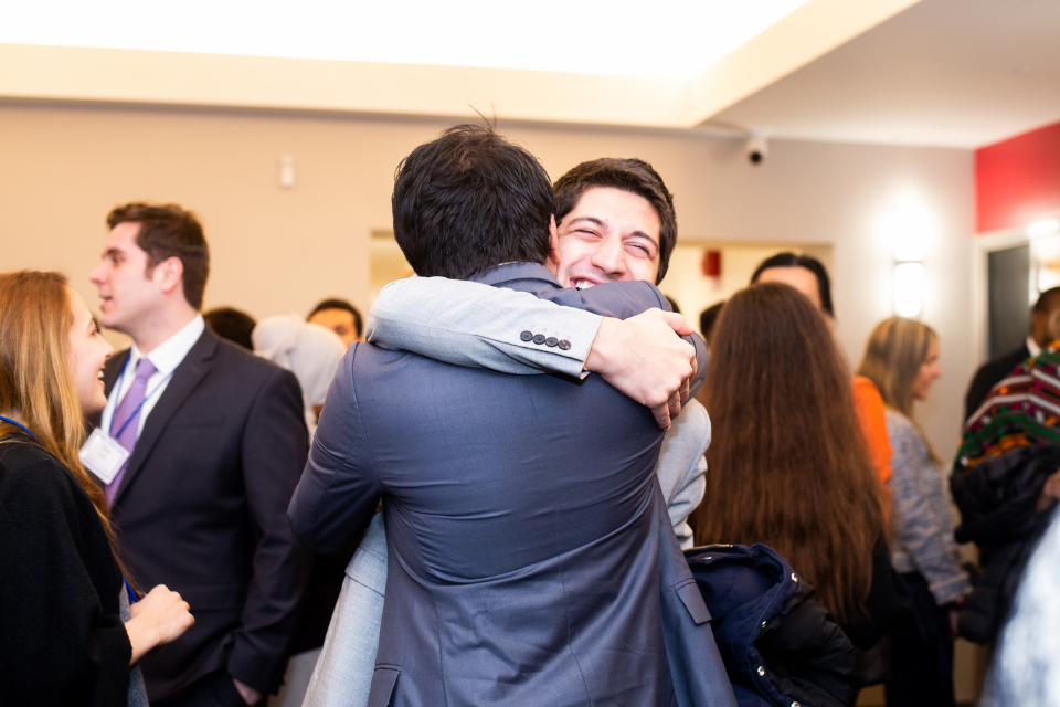 Shota Adamia embraces a fellow Wien scholar at the anniversary celebration