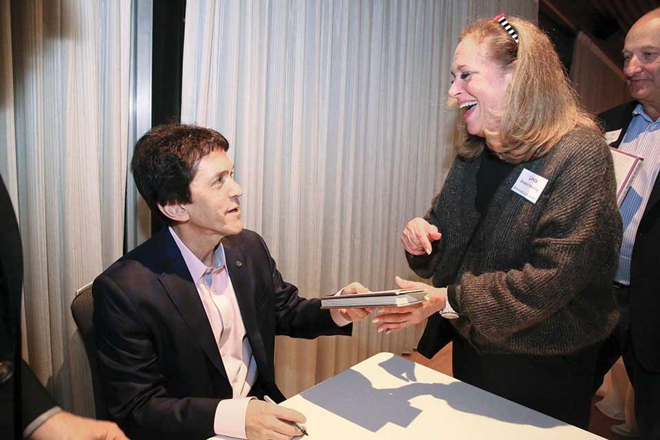 Mitch Albom greeting an attendee at a book signing at Brandeis