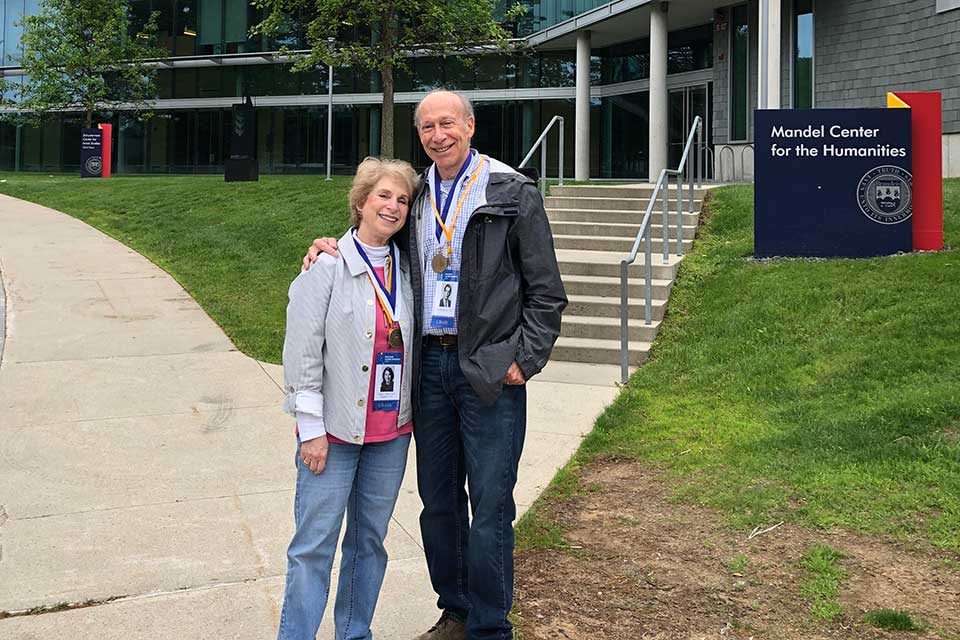 Nancy and Ira Shapiro standing in front of the Mandel Center on the Brandeis campus