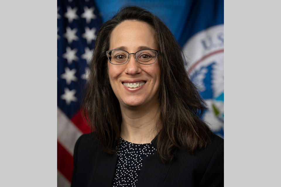 Deborah Waller Meyers smiling in front of an American flag