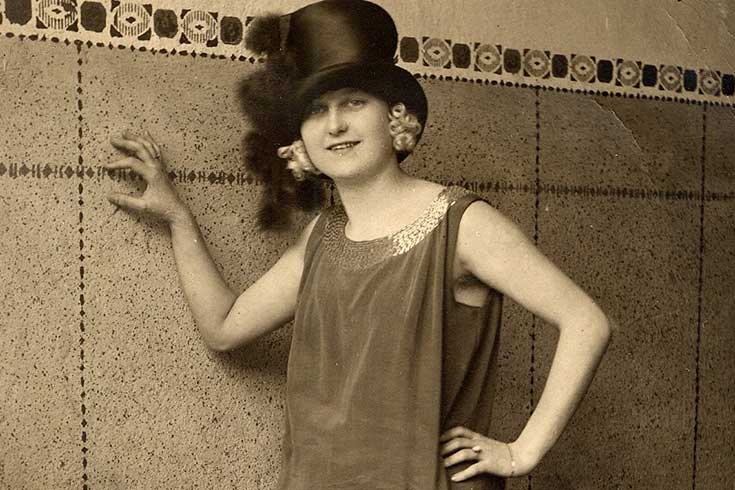 Sepia tone image of woman dressed in 1920s style clothing