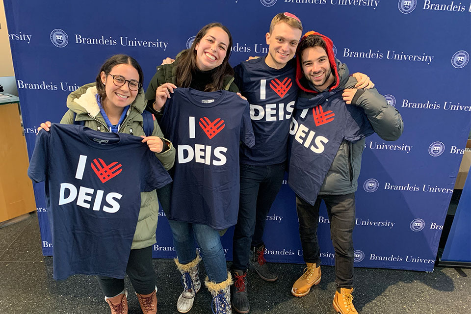 four students hold up "I heart Deis" t-shirts